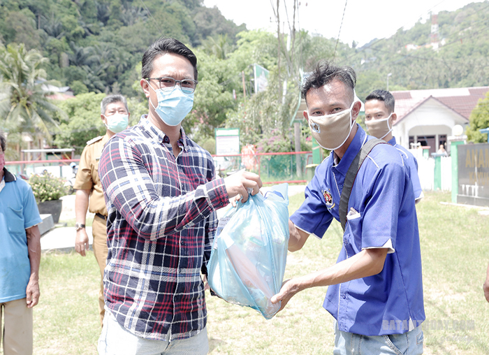 Salah satu donatur pada Program PWI Peduli menyerahkan paket sembako kepada anggota PWI